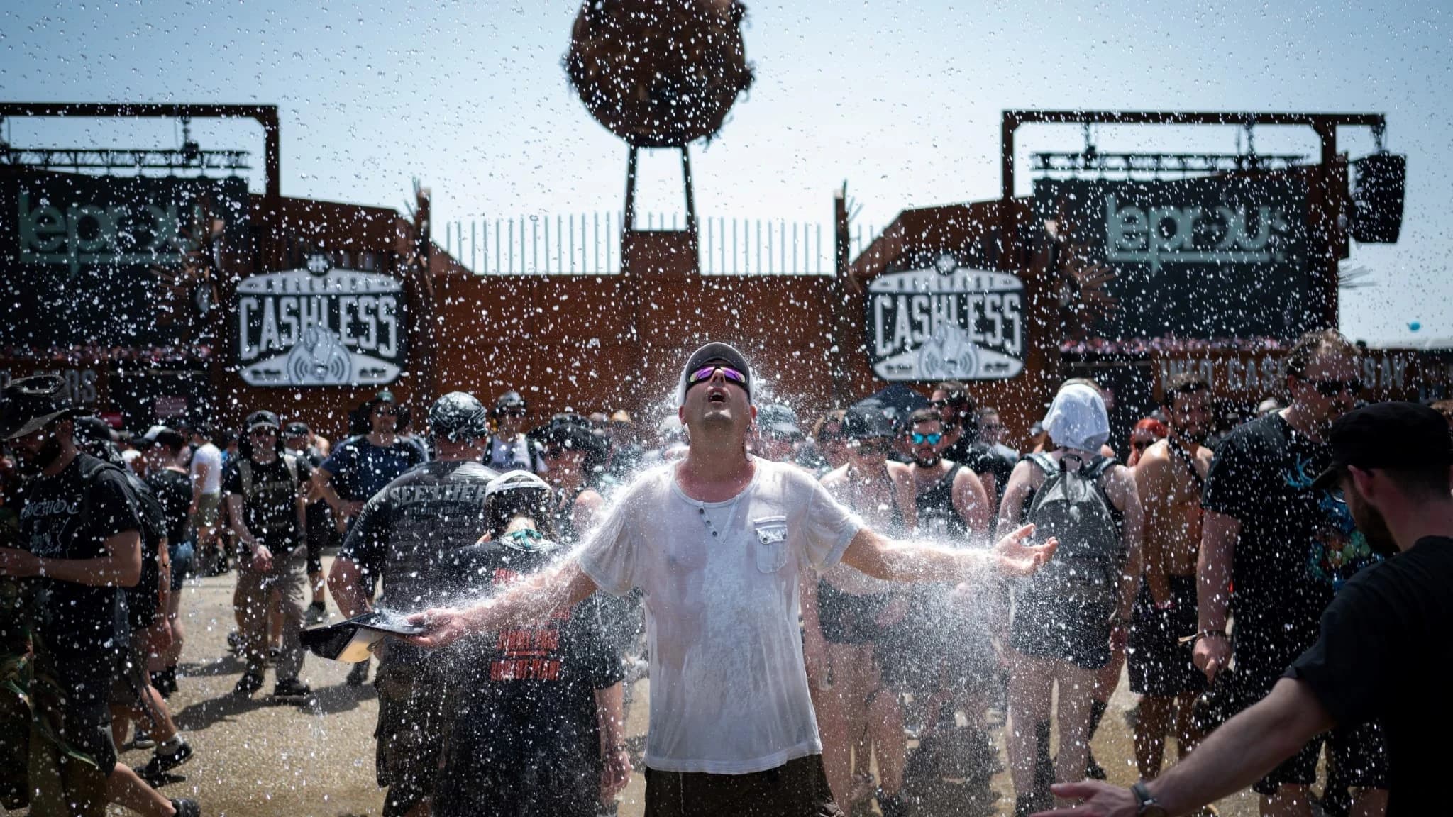 A man being sprayed with water during a festival (source : www.bfmtv.com)